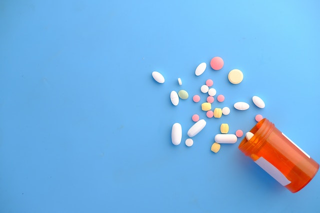pill bottle with pills on blue background